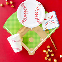 Red backdrop showing baseball diamond placemat, stitched cup, round baseball plate, caramel popcorn, and gold fork.