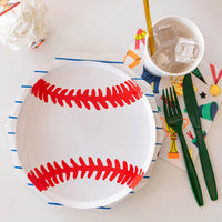 A close-up view of a baseball paper plate styled with playful party napkins, striped cups, and green utensils—perfect for a sporty birthday or team celebration.