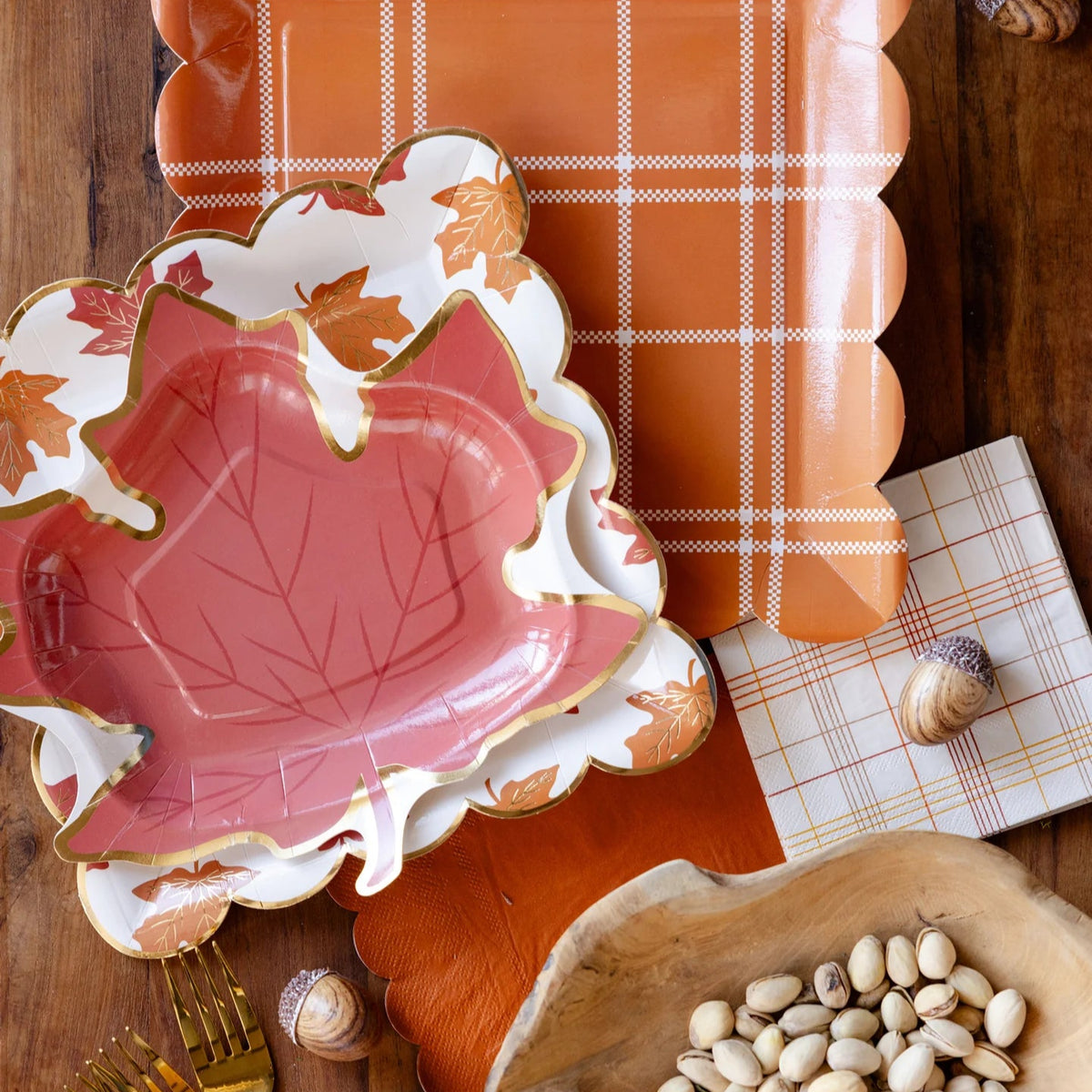 Flat lay of the leaf-print plates layered over an orange plaid tray.