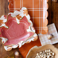 Flat lay of the leaf-print plates layered over an orange plaid tray.
