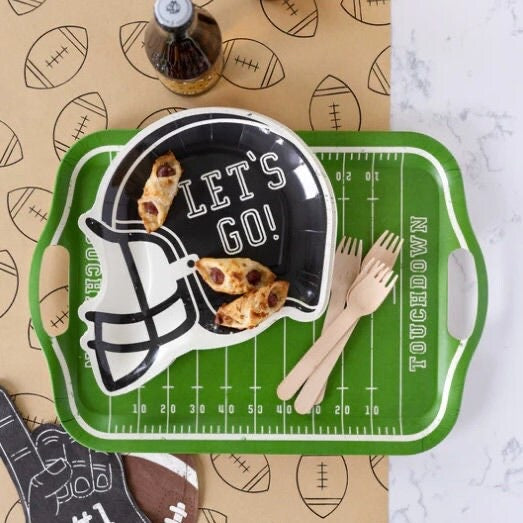 Football party table featuring football helmet shaped paper plates