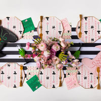 Overhead tablescape showing witch hat and broom lunch napkins with plates and flowers