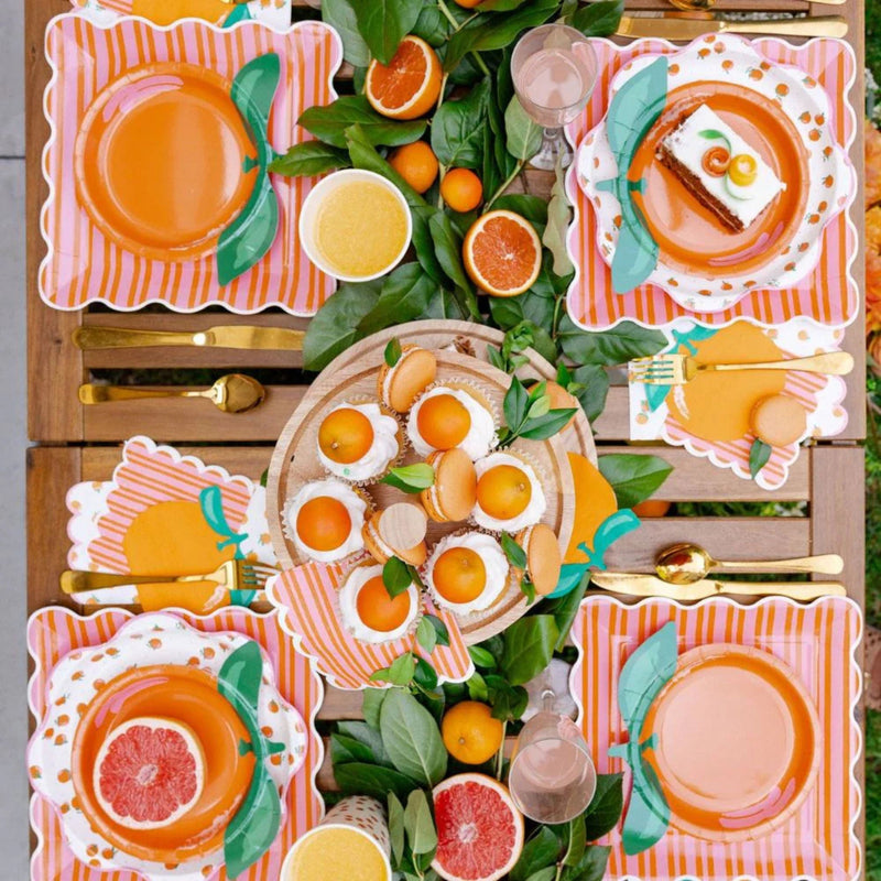 Table spread featuring orange and citrus-themed party supplies.