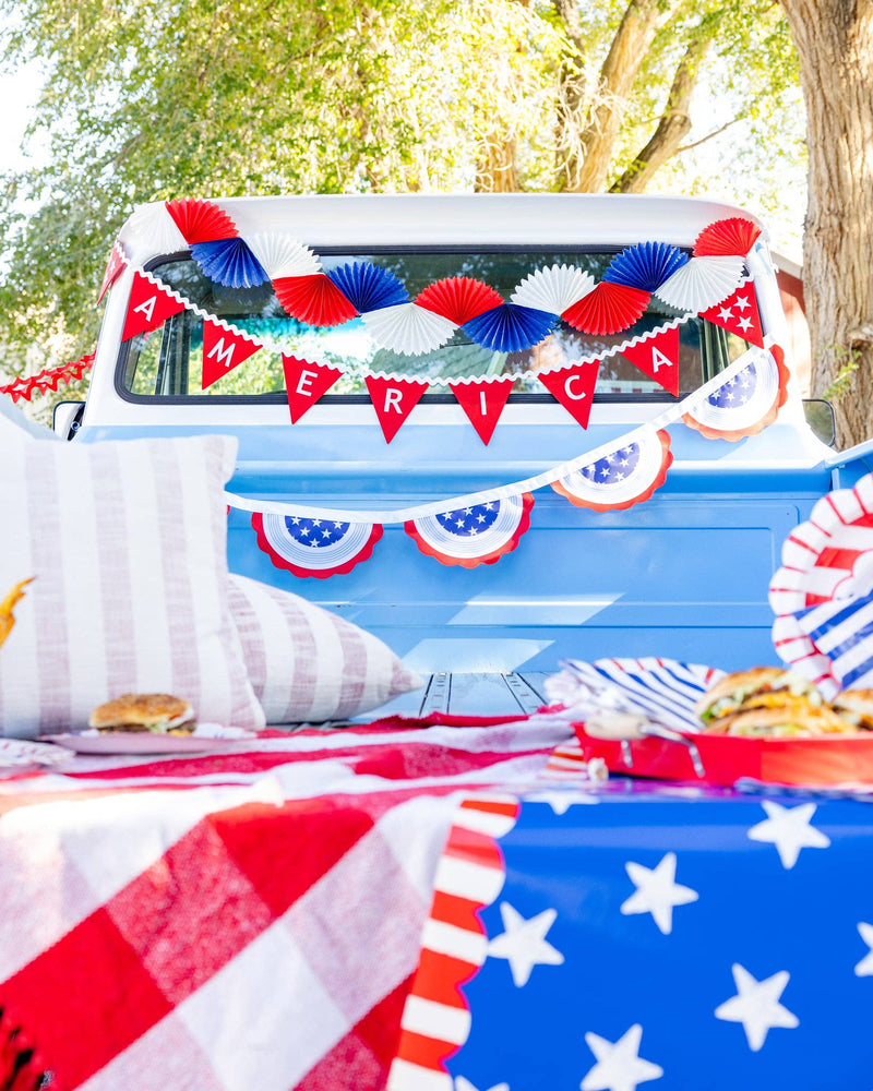 Patriotic Labor Day tailgate party with American flags, festive table runner, food, drinks, and party banners