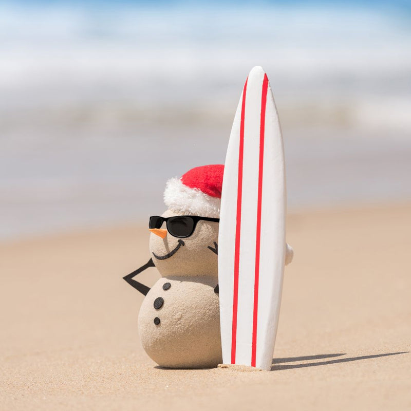 Christmas ornaments and shells on sand