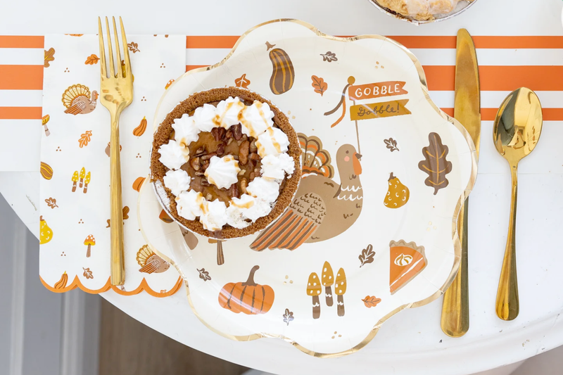 Close-up tablescape featuring icons plate with “Gobble” banner turkey artwork.