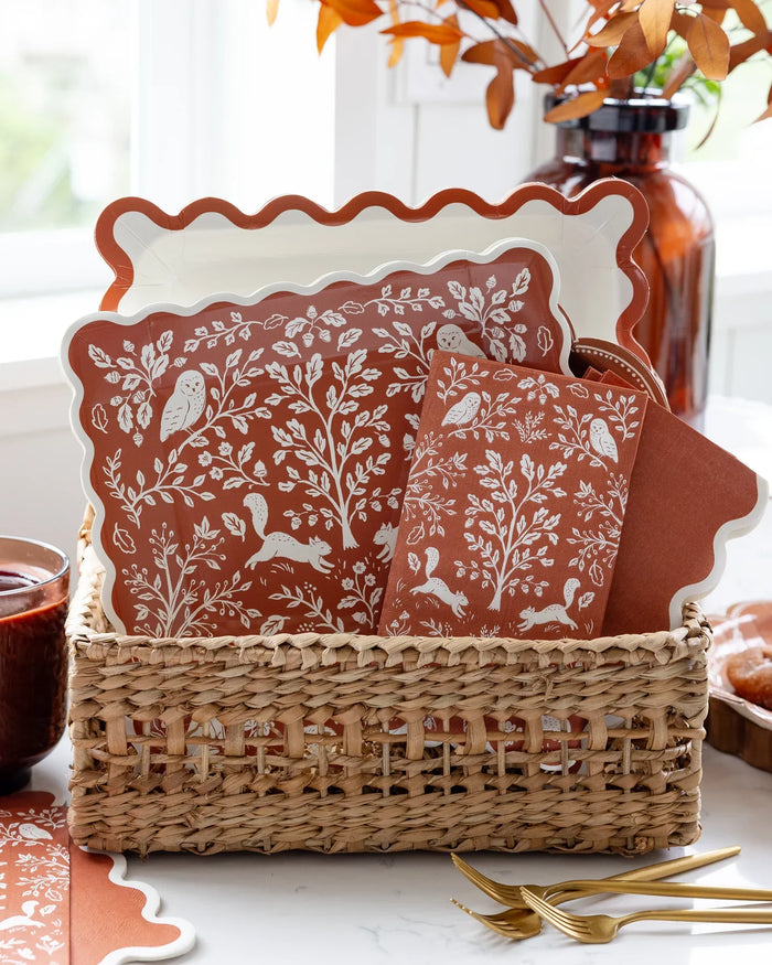 Close-up of the folk-art illustration detail showing deer, acorns, and florals in cream on rust.