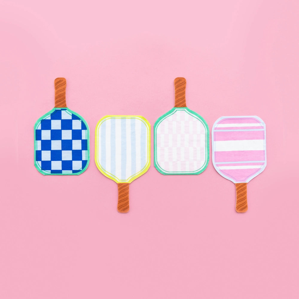 Row of four paddle‑shaped napkins on pink background: royal‑blue check, lemon‑stripe, blush gingham, and pink‑stripe designs.