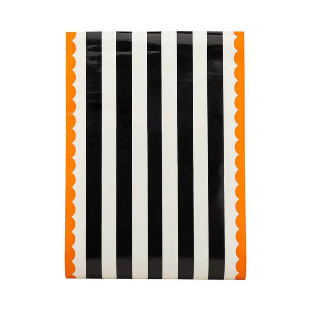 Flat view of the Orange and Black Striped Paper Table Runner showing black and white stripes with orange scalloped edges.