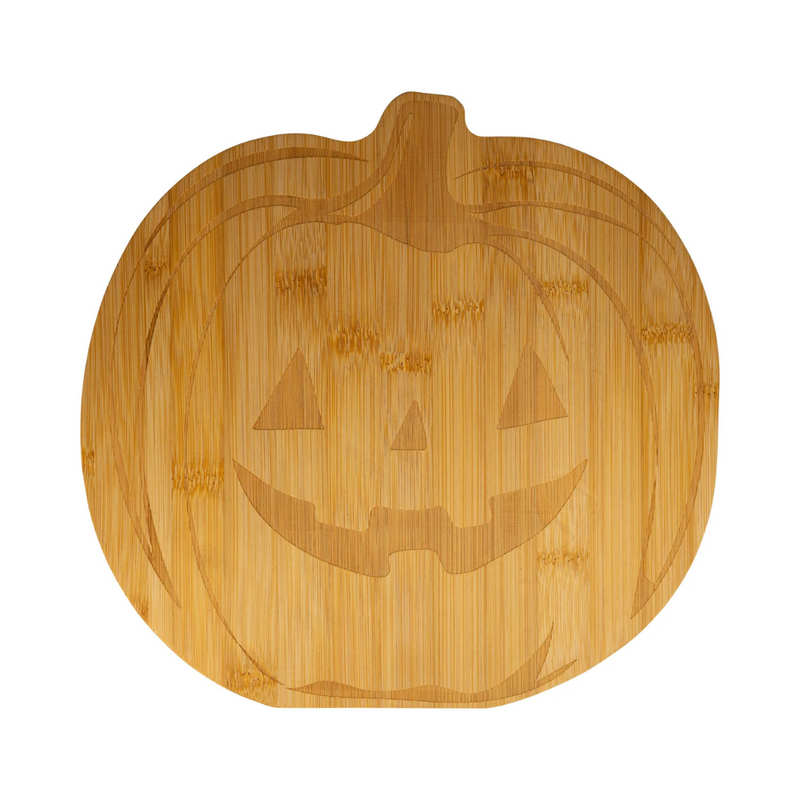 Close-up of the engraved jack-o'-lantern face on the bamboo cutting board.
