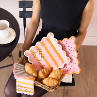 Person holding a basket of croissants with decorative signs in a casual setting.