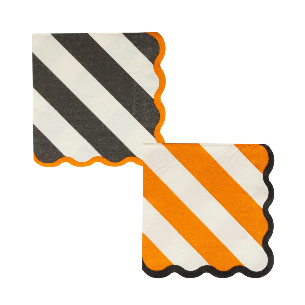 Two paper napkins side by side — one black and white striped with orange scalloped edge, and one orange and white striped with black scalloped edge.
