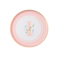 Single round petal pink polka dot paper plate with floral illustrated number one blue wildflowers sage vine and gold foil rim on white background