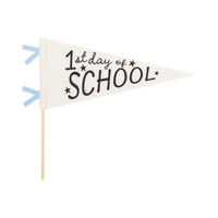 Cream 1st Day of School felt pennant with black screen-printed text and stars, blue felt mini flag accents, and wooden dowel