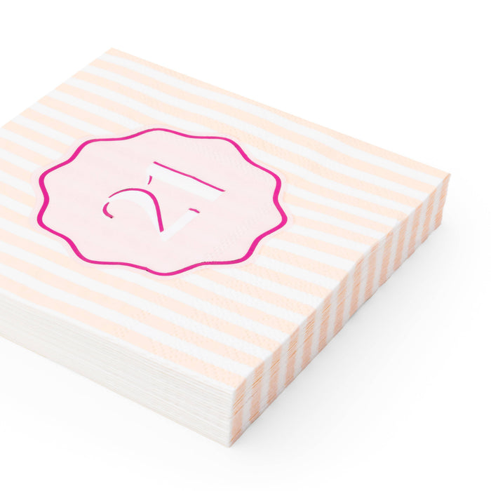 Angled stack of peach and white striped 21st birthday cocktail napkins with pink foil number badge
