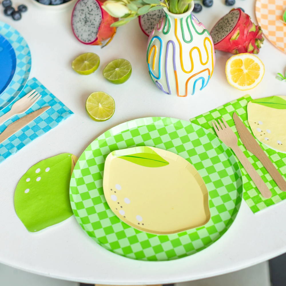 Close-up of Le Dinner Lime Cocktail Napkins paired with matching lemon plates and colorful tableware.