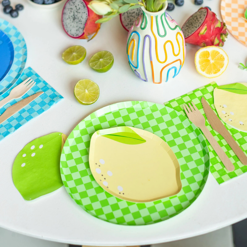 Close-up of Le Dinner Lime Cocktail Napkins paired with matching lemon plates and colorful tableware.
