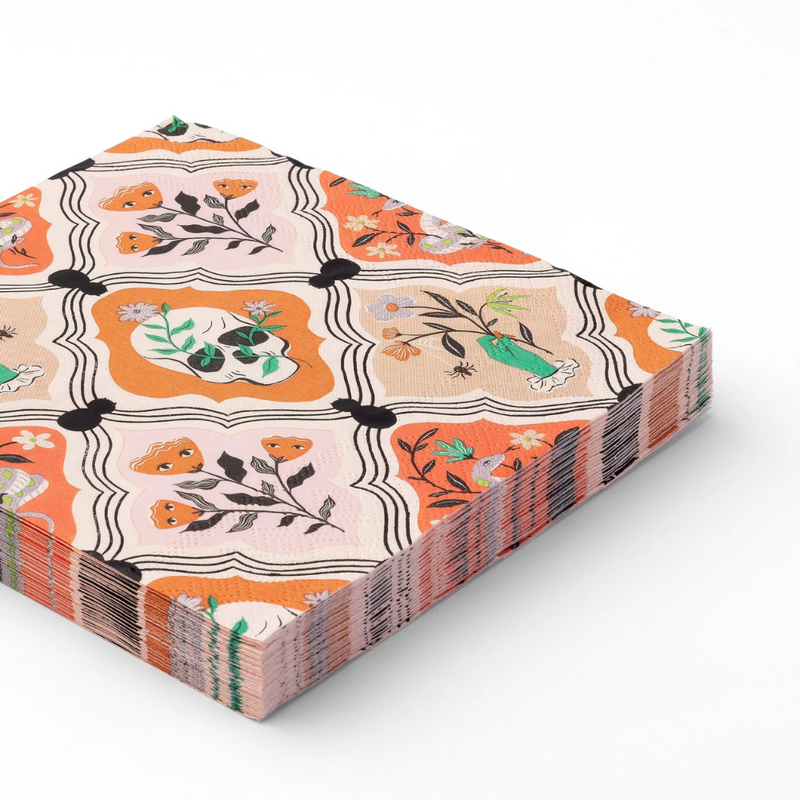 Stack of folded Floral Skulls & Spiders dinner napkins with orange and pink gothic floral skull design.