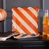 Halloween table setting with orange and white striped plate and polka dot napkins