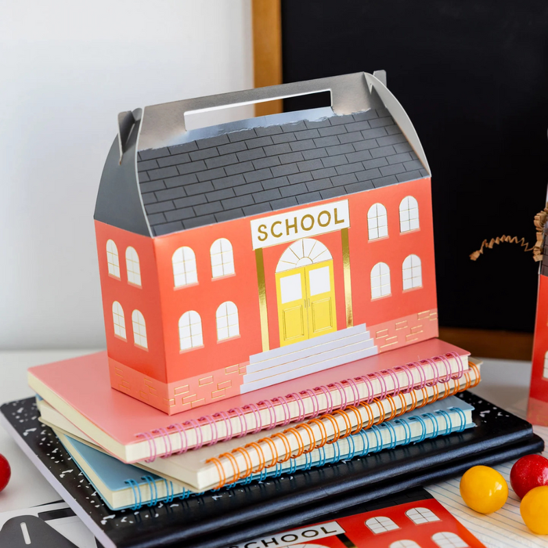 Close-up of filled treat box on spiral notebooks with school supplies