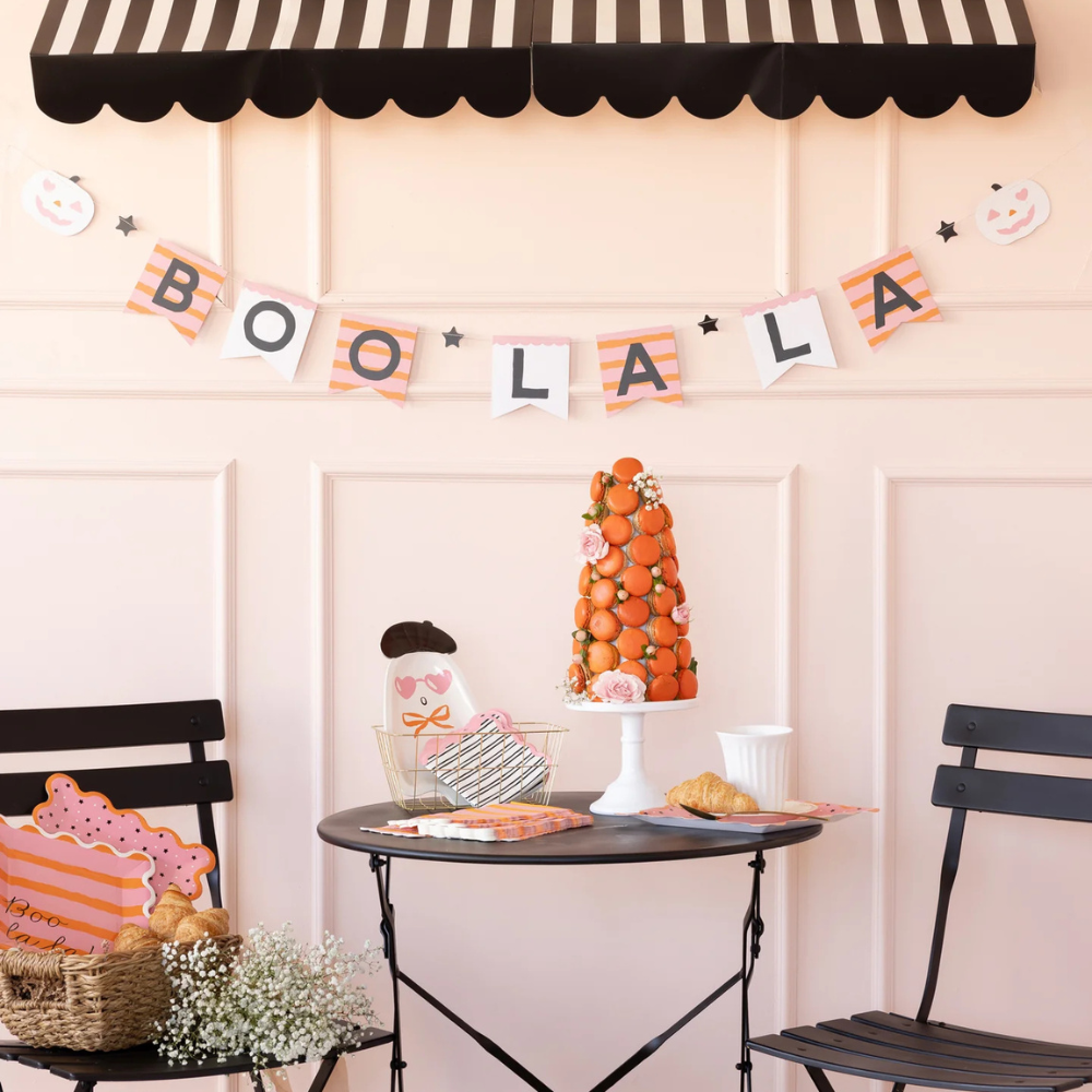 Close-up of the banner styled on a wall with a dessert table and Halloween treats underneath