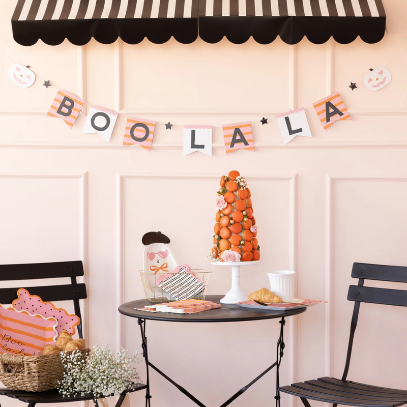 Close-up of the banner styled on a wall with a dessert table and Halloween treats underneath