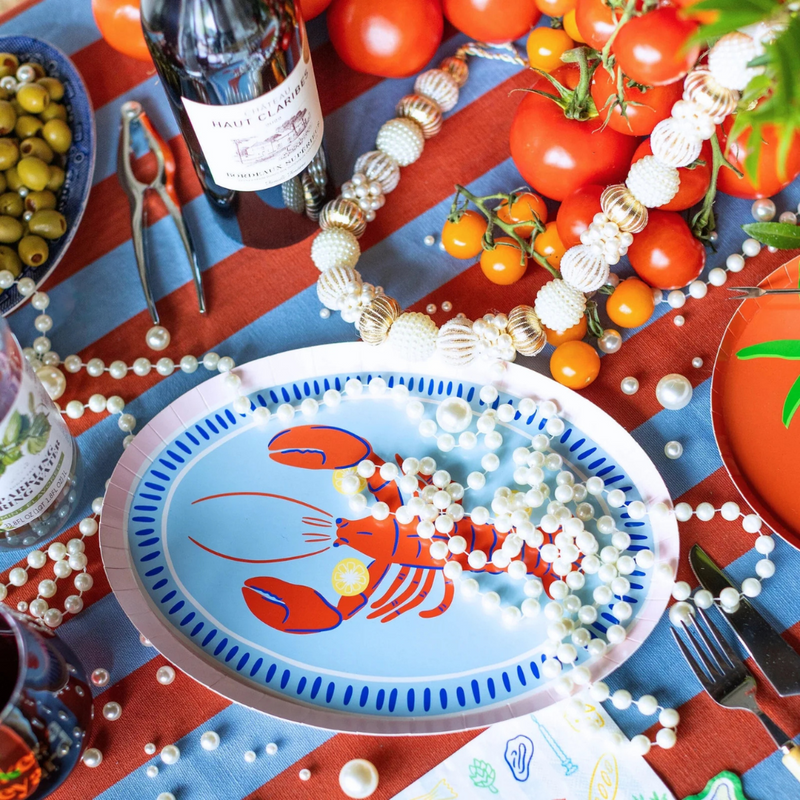 Festive seafood tablescape with Le Dinner Lobster Platter Charger Plate and tomato accents.