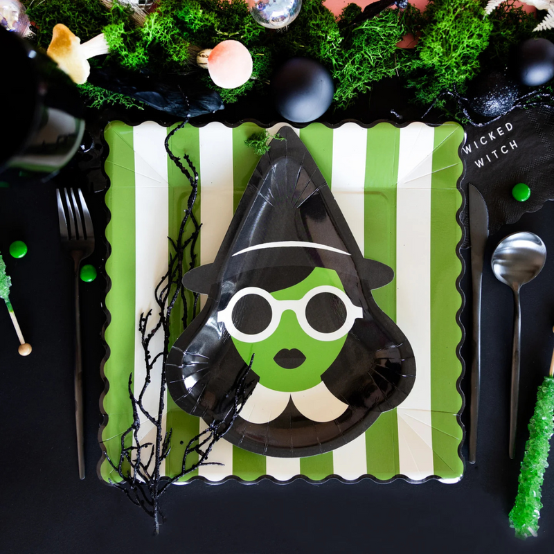 Overhead shot of black-and-green Halloween tablescape featuring Bad Witch plates