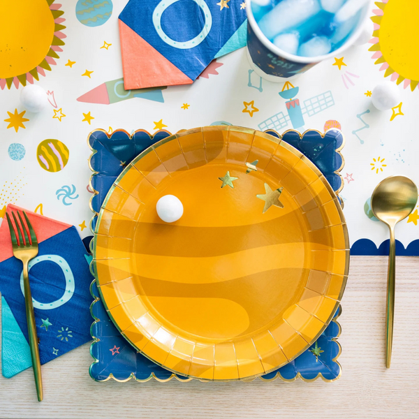 Space party setup with space pattern plate under yellow planet plate