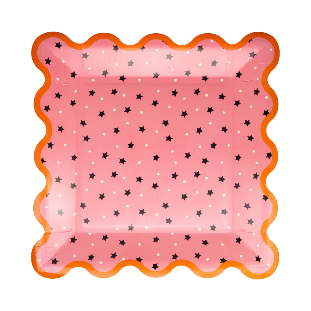 Close-up of a single pink plate with scattered stars and vibrant orange trim