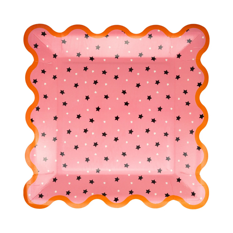 Close-up of a single pink plate with scattered stars and vibrant orange trim