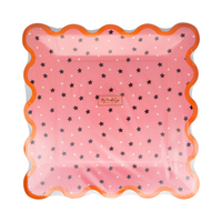 Pink paper plate with all-over black star print and orange scalloped edge, in packaging