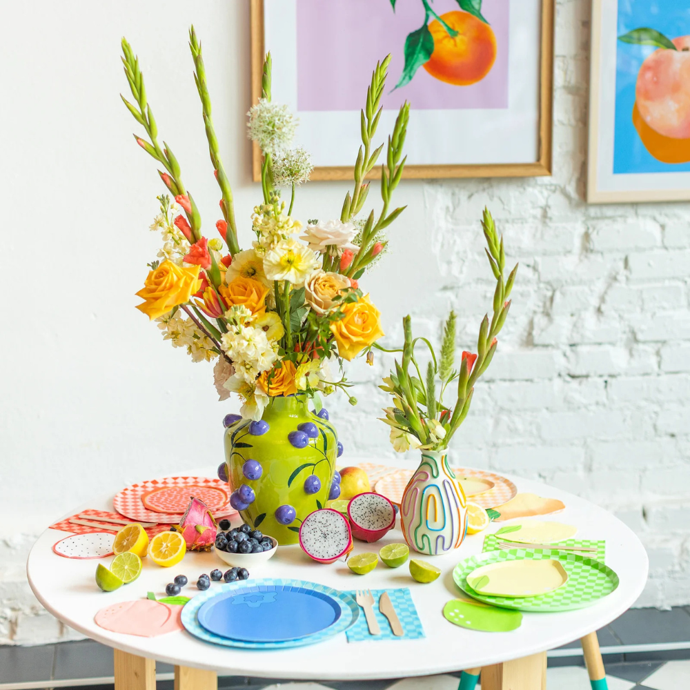 Le Dinner Peach Large Napkins styled on a vibrant fruit-themed table with colorful plates and fresh fruit decor.