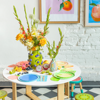 Table styled with Le Dinner Lime Cocktail Napkins alongside lime-themed plates and fresh citrus fruits.