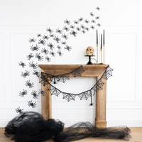 Glitter spider cutouts arranged around a fireplace with matching spider web banner.