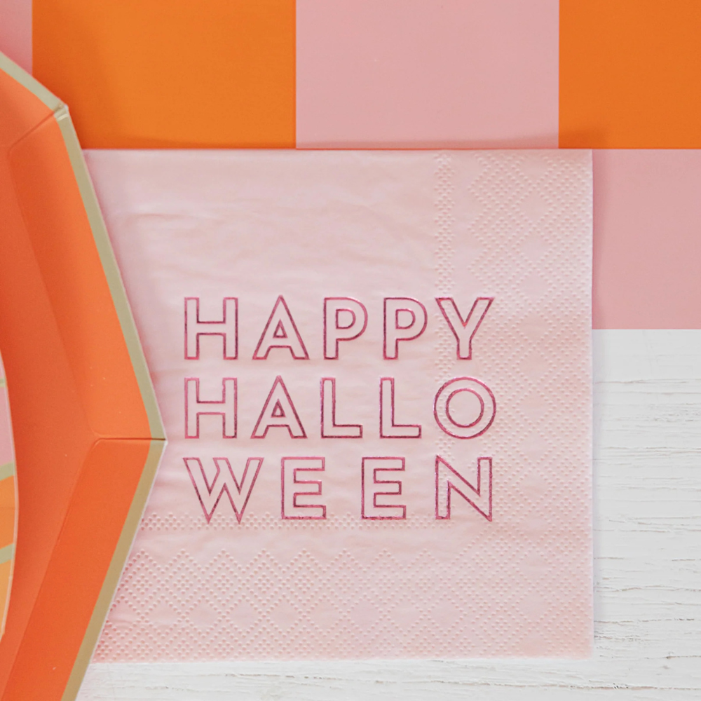 Zoomed-in view of single napkin showing pink background and red “Happy Halloween” text.