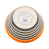 Bottom of a round bamboo fiber bowl with black and cream stripes and an orange scalloped rim, showing the Happy Halloween label.