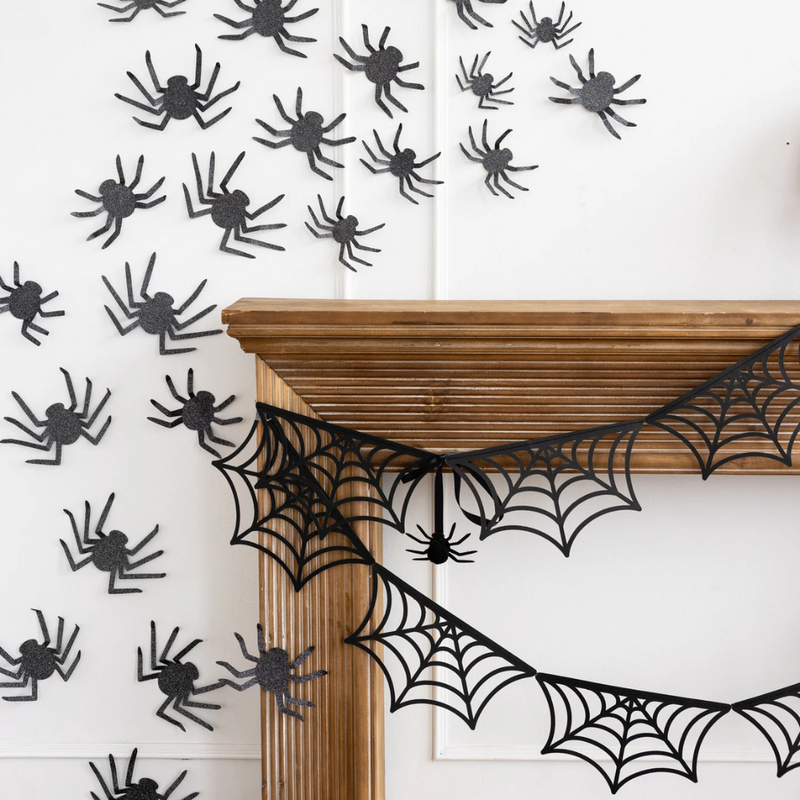 Close-up of black spider web banner hanging from a mantel