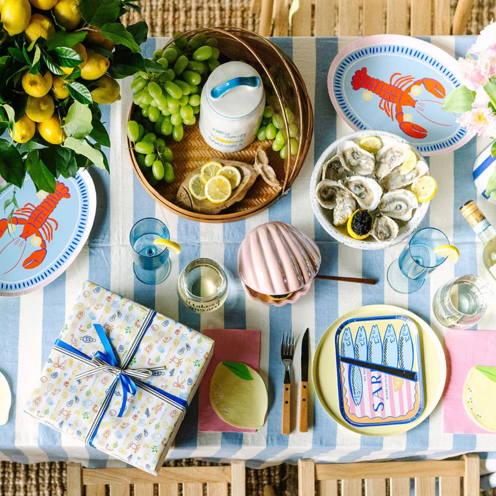 A styled party table with Le Dinner Lemon Cocktail Napkins under plates.