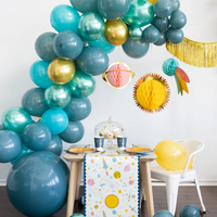 Space-themed party setup with hanging honeycomb planets and balloon arch