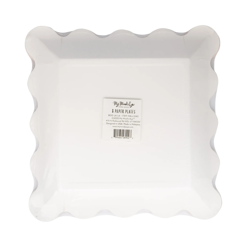 Back of pink paper plate with all-over black star print and orange scalloped edge, in packaging