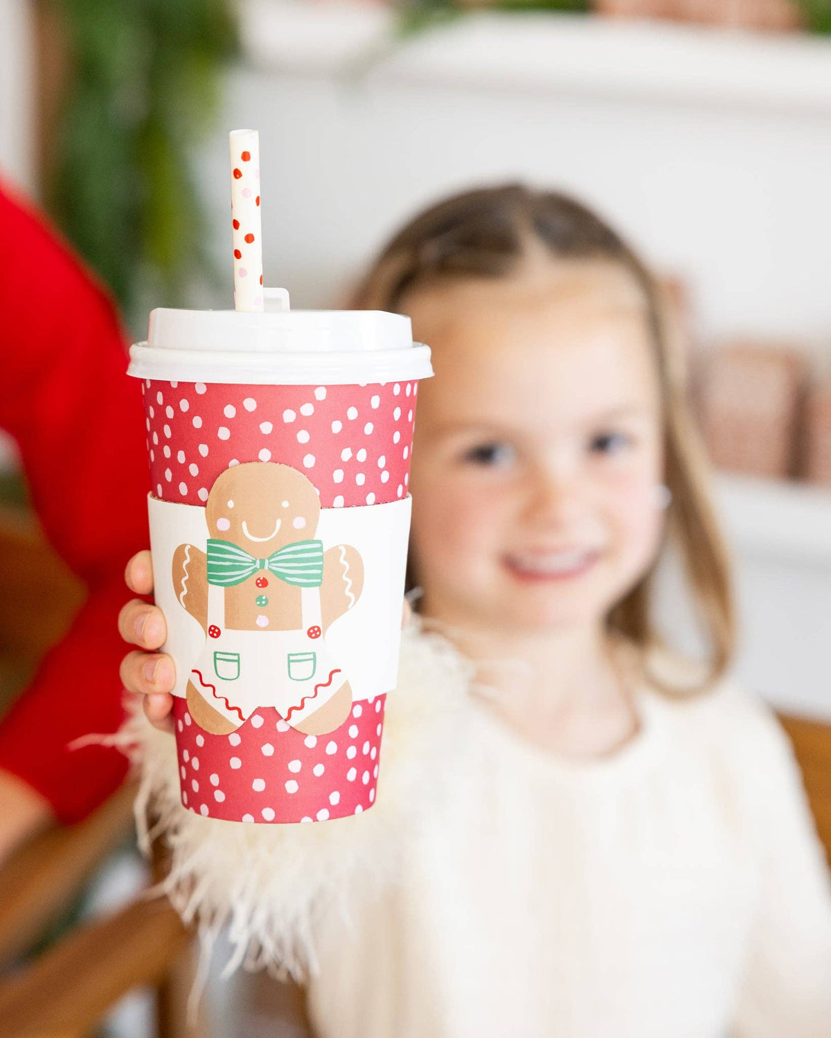 Child in background holding Gingerbread To-Go Cup in the foreground