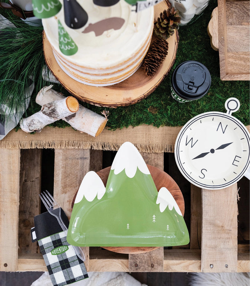 A styled party setup featuring the green mountain plate on a wooden charger, surrounded by adventure-themed décor.