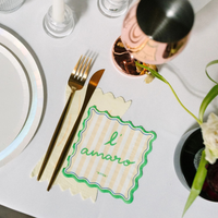 Le Dinner Cocktail Napkin with “l’amaro” text in green and yellow stripes on a table setting.