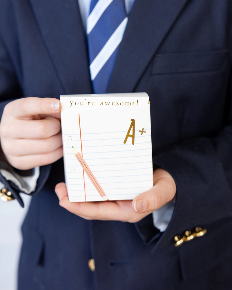 Close-up of a student holding one treat box, with “you’re awesome!” printed at the top flap.
