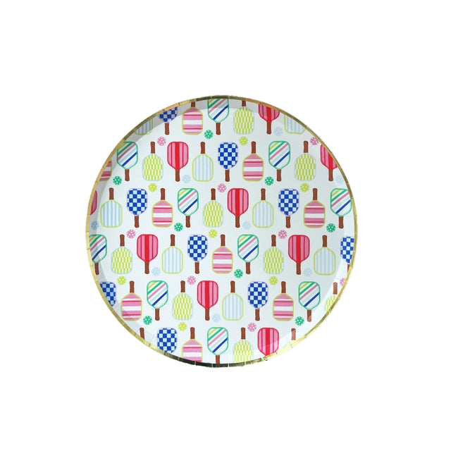 Isolated round dessert plate featuring multicolor pickleball paddles and balls with gold foil rim on white background.