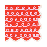 Close-up of red Frosting Cocktail Napkin with white looping frosting pattern and scalloped edge.