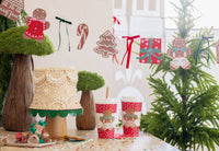 Christmas tablescape featuring Gingerbread To-Go Cups and gingerbread banner with different Christmas-themed shapes and ribbons