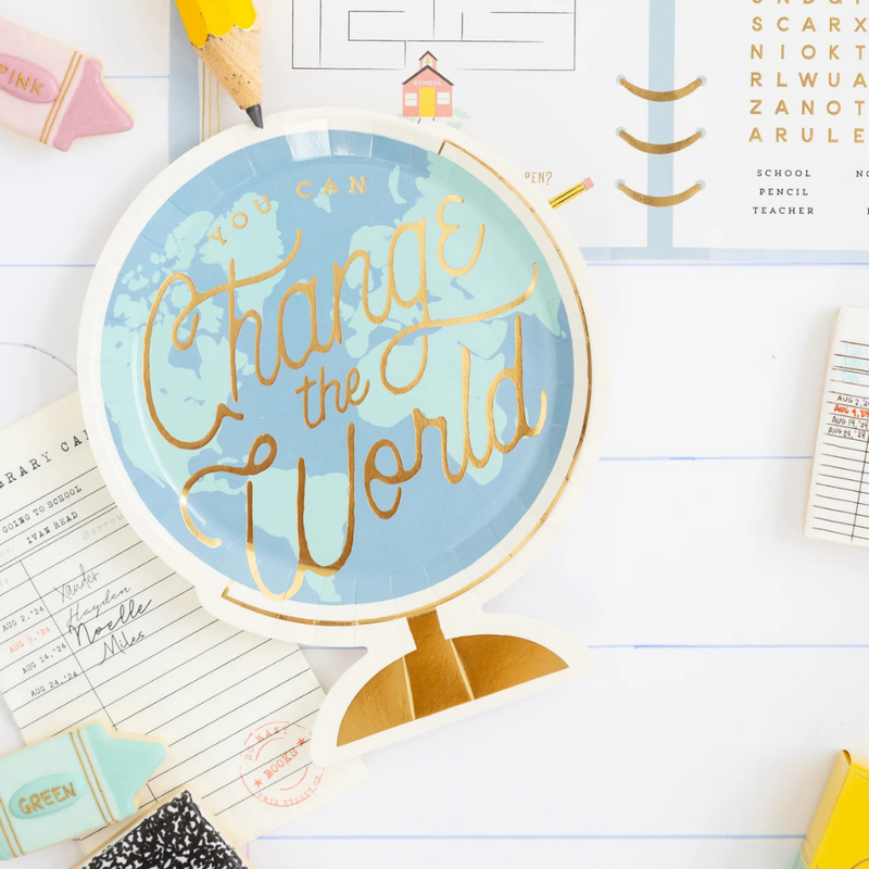 Styled desk flat lay with globe paper plate and school supplies