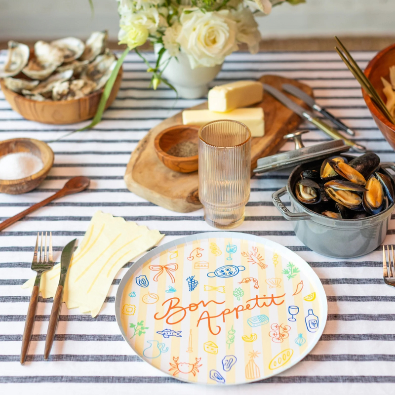 Table set with Le Dinner Pasta Noodle Guest Napkin styled beside a colorful plate of mussels.